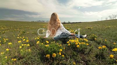 Child on a spring meadow of wild peonies
