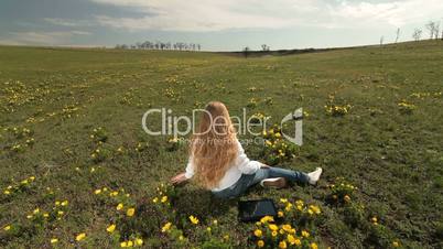 Child on a spring meadow of wild peonies