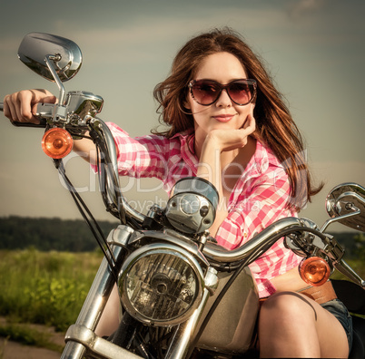 Biker girl sitting on motorcycle