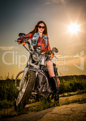 Biker girl sitting on motorcycle