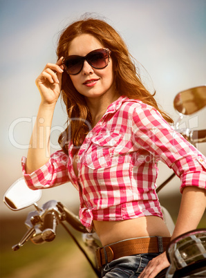 Biker girl sitting on motorcycle