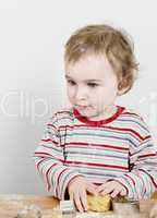 young child making cookies