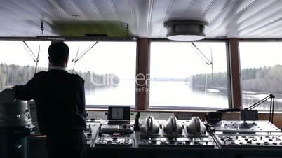 navigation officer driving the ship on the river.
