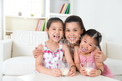 Mother and daughters drinking milk