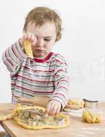 young child playing with dough on wooden desk