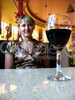 glass of red wine on the table and a girl