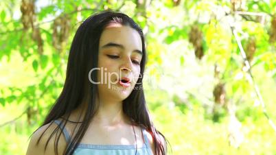 Girl drinking water in summer park