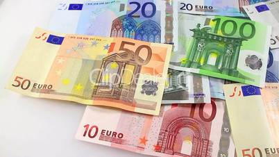 Camera pans left to right over Euro banknotes