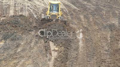 Yellow Bulldozer Raking Clay