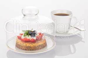 Cheesecake, glass bell and cup of coffee