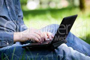 detail of hands and laptop keyboard.