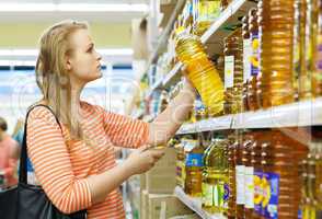 young woman buys sunflower oil