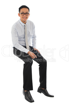 Asian businessman sitting on a transparent block