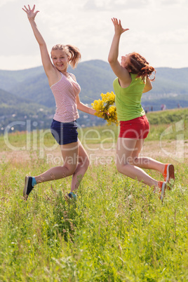 Girlfriends walk and play a meadow