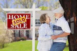Sold Real Estate Sign with Senior Couple in Front of House