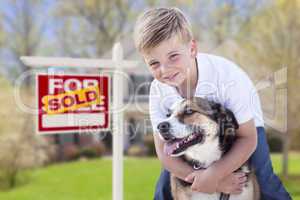 Young Boy and His Dog in Front of Sold For Sale Sign and House