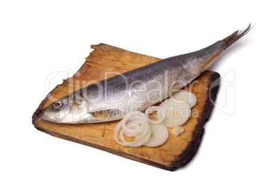 herring with onion rings on old wooden cutting board