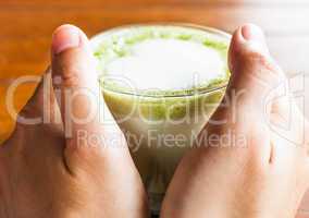 Hands hold hot drink of matcha green tea latte