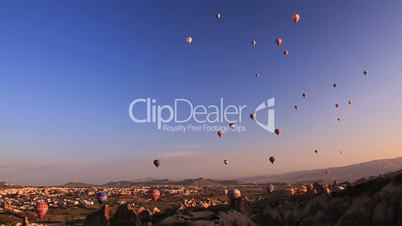 Multicolored balloons rise in the sky.