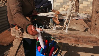 Woman weaving a traditional scarf.