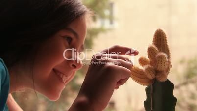 Girl touches a cactus.