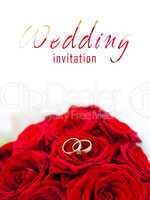 wedding rings on red roses wedding bouquet