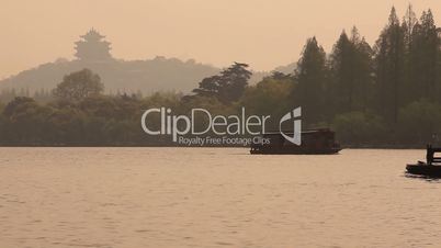 Boats go on the lake with Chinese pagoda.