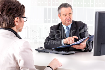 Businessman and businesswoman with documents in the office