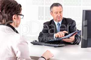 Businessman and businesswoman with documents in the office