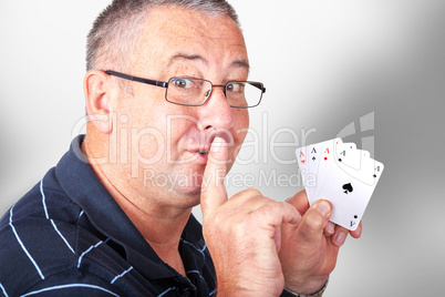 Man with four aces holding finger to mouth
