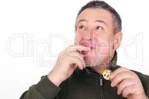 Man eating cookies and licks his fingers