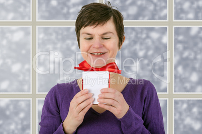 Woman with gift package is in before the snow window
