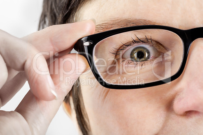 Woman holding glasses to see better