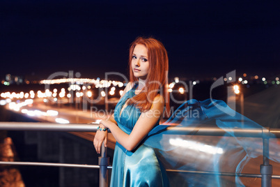Young beauty woman in fluttering blue dress outdoor