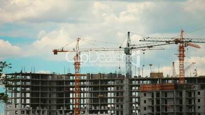 in construction of multi-storey buildings running a lot of cranes and workers