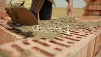 builder lays bricks on a construction site