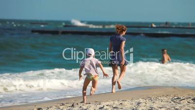 young woman with a child playing on the beach