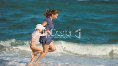 mother and son running together on the beach