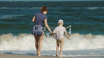 Mom and young son touching down on the sea water