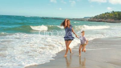mother and son running on the beach