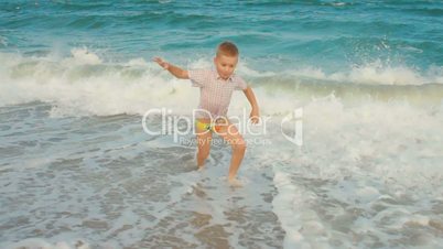 little boy playing with the waves