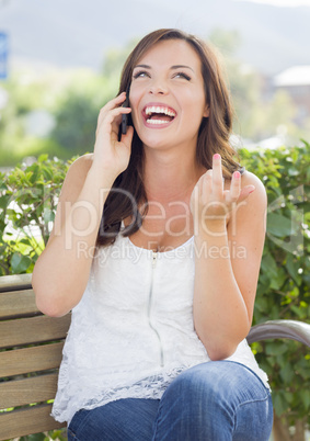 Young Adult Female Talking on Cell Phone Outdoors on Bench