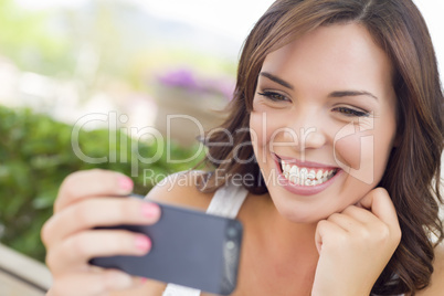 Young Adult Female Texting on Cell Phone Outdoors