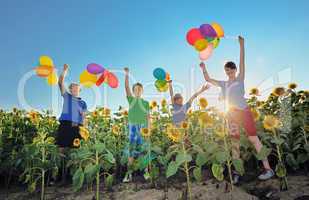 happy childrens jumping on meadow with balloons