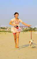 girl running with her dog on the sand