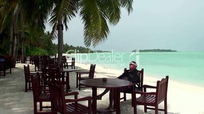 smoking man in a bar on the beach (Maldives)