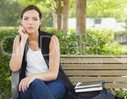 Melancholy Young Adult Woman Sitting on Bench Next to Books.