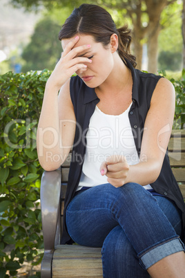 Upset Young Woman Sitting Alone on Bench