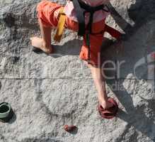 Kind klettert an einem Kletterfelsen
