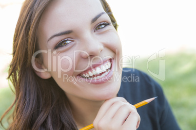 Portrait of Pretty Young Female Student with Pencil on Campus